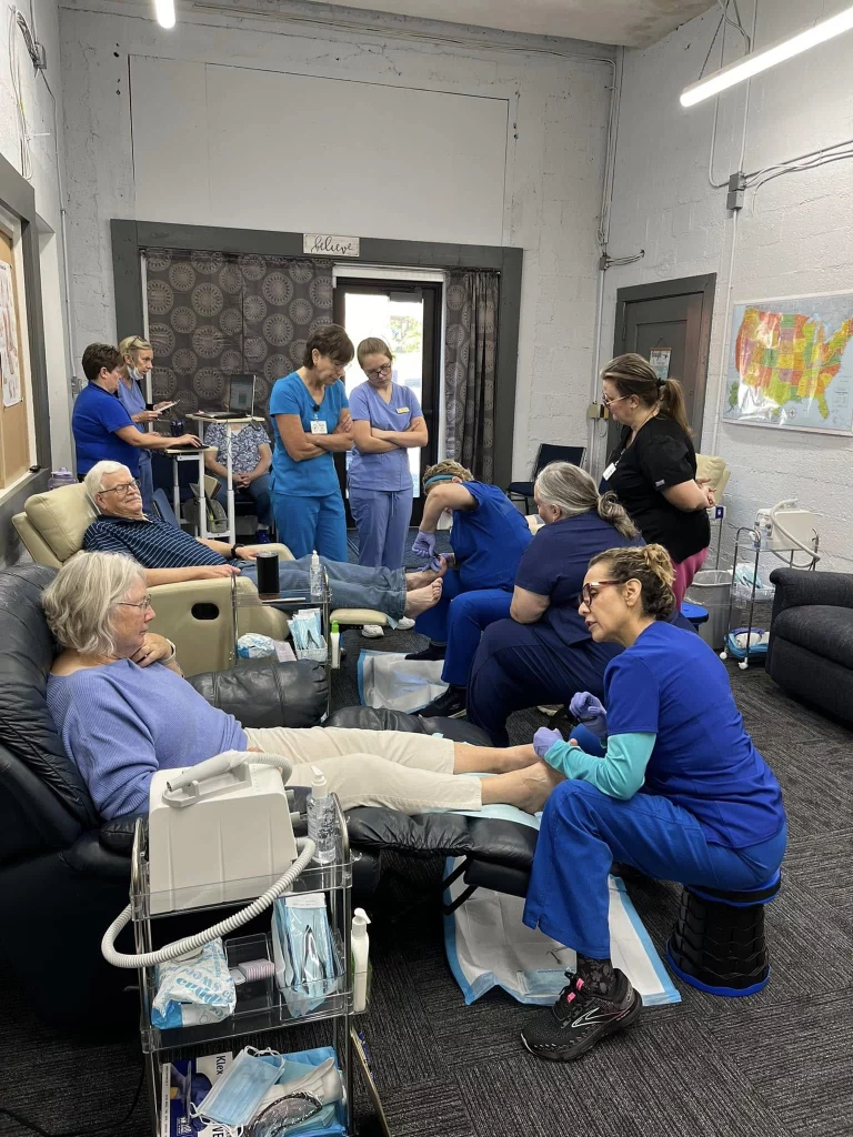 Nurses and patients in recliners during a hands-on foot care training session